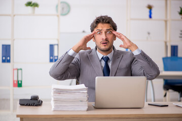 Young male employee sitting at workplace