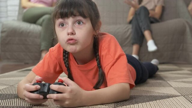 Child attention on video game. A little girl pay attention on her video game laying on the floor.