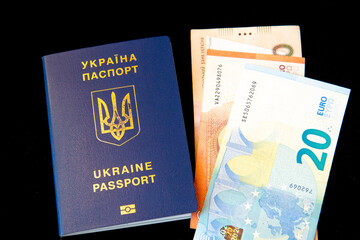 Ukrainian passport with ukrainian and european money on black background. Euros and hryvnias