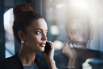 She wont reject any opportunity that calls. Shot of a young businesswoman talking on a cellphone in...
