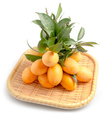 Fresh ripe Marian Plum, or Mayongchid named in Thai, Thailand Tropical Fruits with green leaves served on the tray isolated on white background. Clipping path