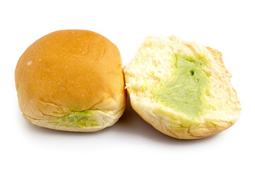 Close up of soft buns stuffed with sweet pandan custard in whole and half cut, Thai dessert custard buns isolated on white background. Clipping path.