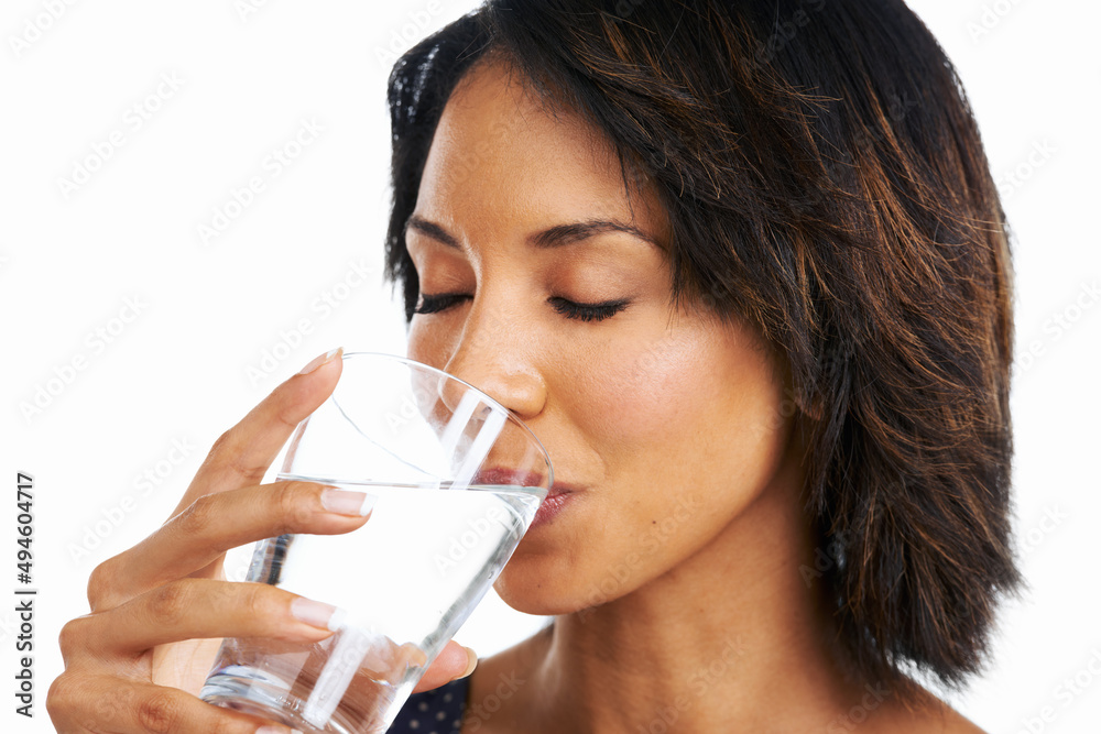 Wall mural My lifestyle. Studio shot of an attractive young woman sipping a glass of water isolated on white.