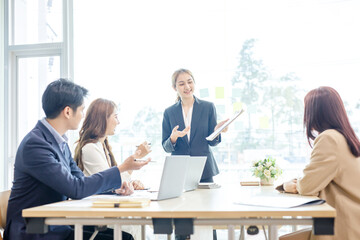 Entrepreneurs and business people conference in modern meeting room, happy multiracial coworkers have fun cooperating working together at office meeting, asian teamwork concept