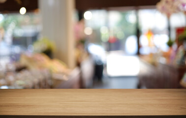 Empty wooden table in front of abstract blurred background of coffee shop . can be used for display or montage your products.Mock up for display of product