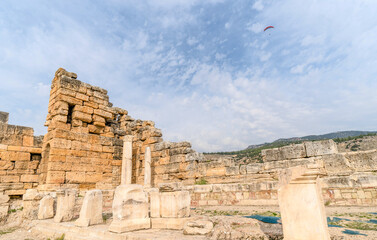 A tourist paraglider is flying over the ruins of the ancient holy city hierapolis