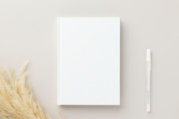 White book blank cover mockup on a beige background, flat lay, mockup