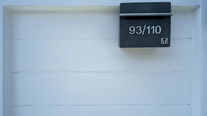 Square white wall background with numbered sign.