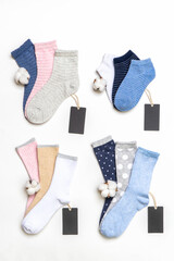 Various modern trendy women's cotton socks set with cotton flowers and price tags on white background. Fashionable socks store. Socks shopping, sale, merchandise, advertisement concept
