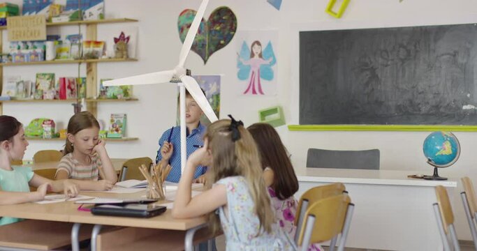 Elementary School Stem Robotics Classroom Diverse Group of Children Building and Programming windmill ecology robot concept. Together Talking and Working as a Team. Creative Robotics Engineering