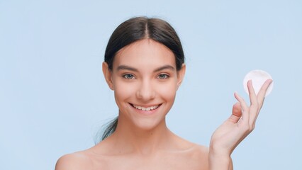 Young positive fresh looking beauty model demonstrates easiness of applying skin care product using a cotton pad   Skin care and clear skin concept. © pavel_dp