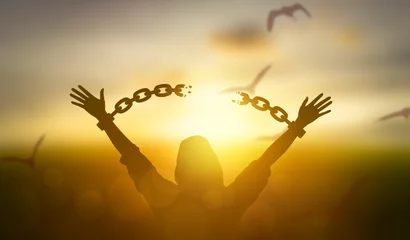 Foto op Plexiglas silhouette women hand up and broken chain and bird sunrise background .freedom concept © thekopmylife