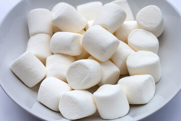 Delicious white marshmallows on blue background.