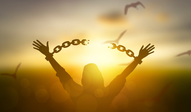 silhouette women hand up and broken chain and bird sunrise background .freedom concept