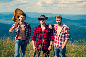 Group of men friends hiking. Outdoor music festival. Group of friends on country walk on a summer...