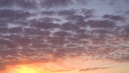 Beautiful evening blue sky at sunset with flaming bright light clouds. A warm summer evening at sunset. Bright sunset.