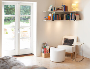Fototapeta na wymiar A homely and stylish space. An empty living room complete with an armchair and bookcase.
