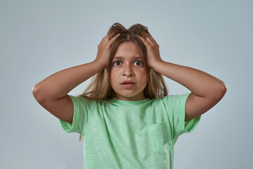 Fototapeta premium Partial of shocked little girl touching her head