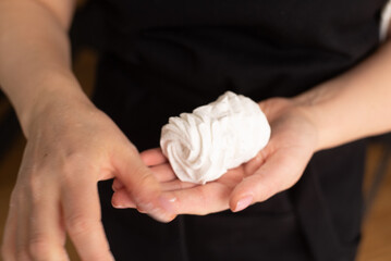 Close up of confectioner's hands holding marshmallow