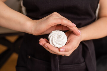 Fototapeta premium Close up of confectioner's hands holding marshmallow