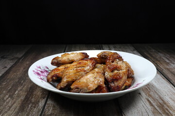 Traditional grilled spicy chicken wing serving on the plate. Famous appetizer menu in restaurant.  