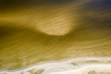 Morze Bałtyckie, widok z lotu ptaka z drona lecącego nad pustą, piękną plażą. Drobne fale...