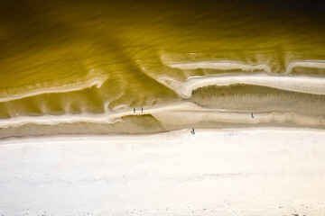 Morze Bałtyckie, widok z lotu ptaka z drona lecącego nad pustą, piękną plażą. Drobne fale...
