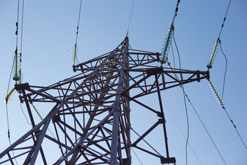 An iron tower with electric wires on a blue sky background, the concept of progress energy