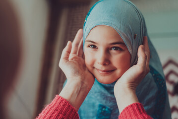 Happy Muslim family. Mother holding child daughter in her hand. Mom and daughter in hijabs smiling...