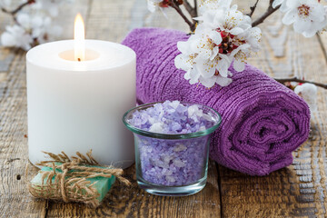 Obraz na płótnie Canvas Soap, sea salt with towel and burning candle with flowering branch