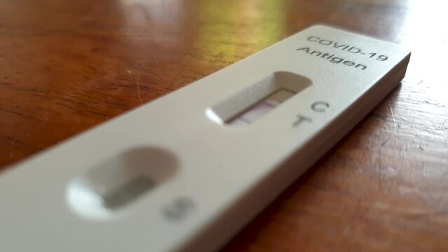 A COVID-19 rapid lateral flow antigen testing kit with a positive result for corona virus, close-up of test