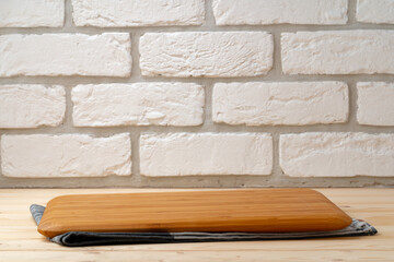 Cutting board with cotton napkin on wooden table