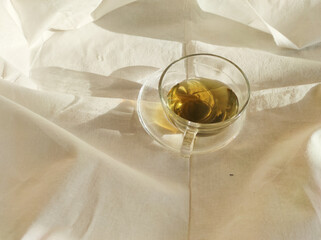 Cup of tea on white textile background 