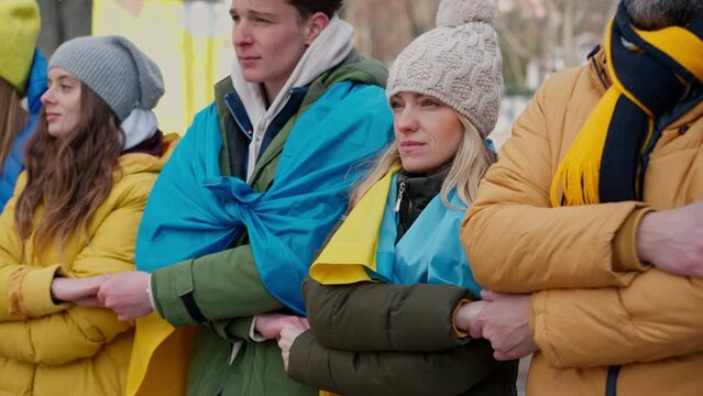 Protestors with Ukrainian blue and yellow flags protesting against war in Ukraine in street