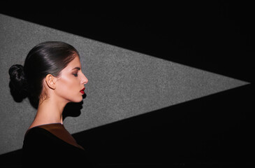 She has a point, and its sharp. A beautiful fashion model highlighted by a shaped portion of light.