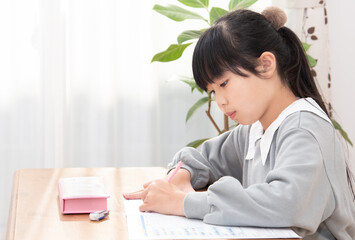 リビングで宿題をする日本人の小学生