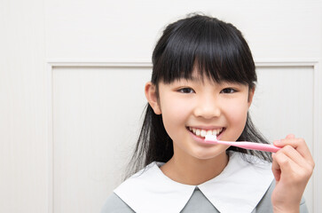 笑顔で歯磨きをする日本人の女の子