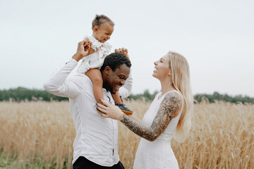 Father riding his child on his shoulders in wheat fields