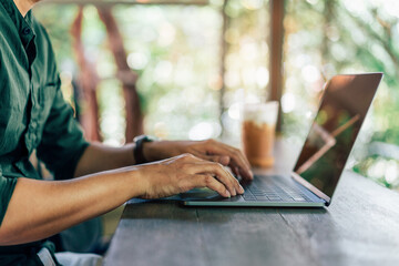 closeup hands of businessman working at cafe, Man typing keyboard on laptop or computer.