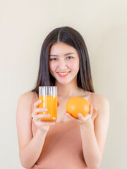 Beautiful beauty woman Asian cute girl feel happy drinking orange juice for good health in the morning , enjoying time in her home  white bedroom background - lifestyle beauty woman concept