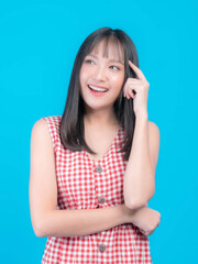 Fototapeta premium Young beautiful Asian woman pointed a finger to her head and smiled isolated on green background ,She think that she is coming up with new plans to get her work done - thinking woman concept