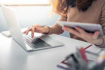 Corporate businessman working at office desk, his is working with a laptop and connecting with a digital touch screen tablet. Business objects of engineers office with construction engineer architect.