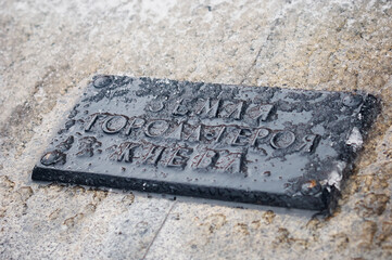 The inscription in Russian: the land of the city of the hero of Kyiv. A fragment of the monument to the fallen heroes of World War II.