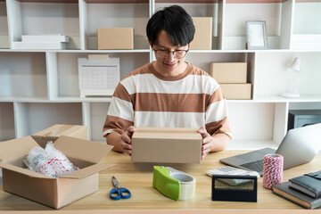 Online shopping concept the online shop agent packing his product into the box and sealing it deliberately