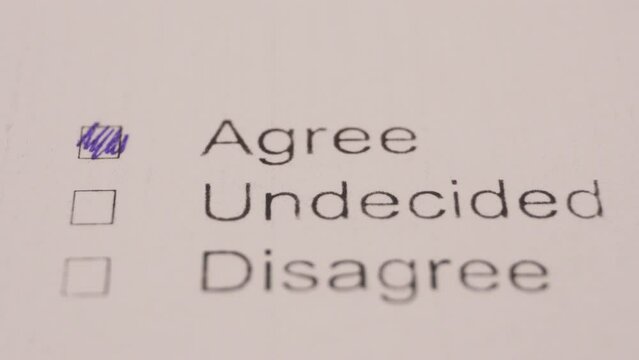 Person Marking The Word Agree As The Answer In Examination Test. Close Up