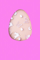 Easter egg cut out of paper and eggs, bunny and butterflies. Creative Easter holiday concept with copy space