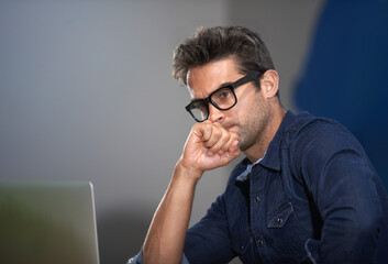 Bringing his business into focus. A thoughtful young entrepreneur using his laptop.