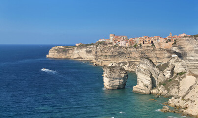Fototapeta na wymiar Bonifacio citadel above limestone cliff overlooking the sea on clear blue sky- corsica