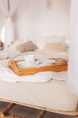 stand with a cup of coffee on the bed