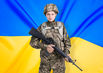 Fototapeta premium Armed soldier in military camouflage uniform and Ukrainian flag on background. Stop war